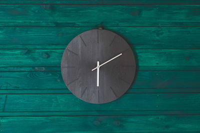 Close-up of clock on wooden wall