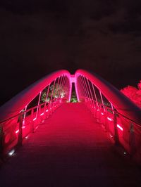 Illuminated ferris wheel against sky at night