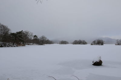 Scenic view of snow covered field against sky