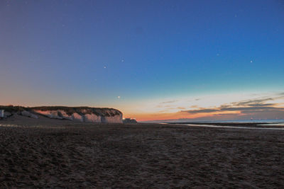 Scenic view of beach against sky during sunset