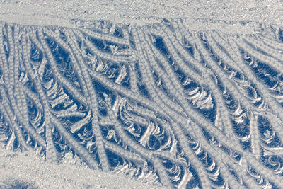 Full frame shot of tire tracks on snow covered land