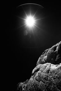 Low angle view of sun shinning against sky