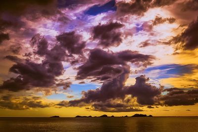 Scenic view of sea against cloudy sky at sunset