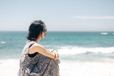 Woman looking at sea against sky