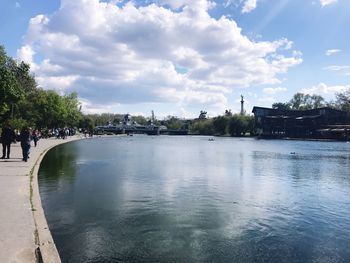 Scenic view of river by buildings against sky