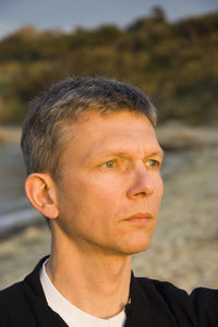 Close-up of thoughtful man looking away at beach