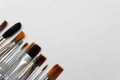 High angle view of make-up brushes against white background