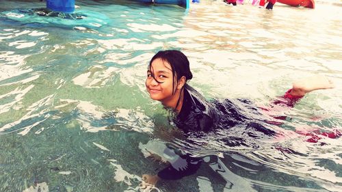 High angle view of smiling woman swimming in pool