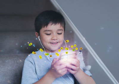 Portrait of girl blowing bubbles while standing against wall