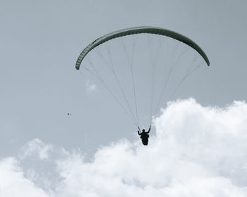 Low angle view of person paragliding against sky