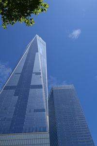 Low angle view of skyscraper against blue sky