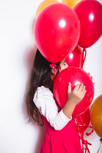 Midsection of woman holding red balloons
