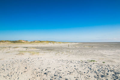 Scenic view of desert against clear blue sky