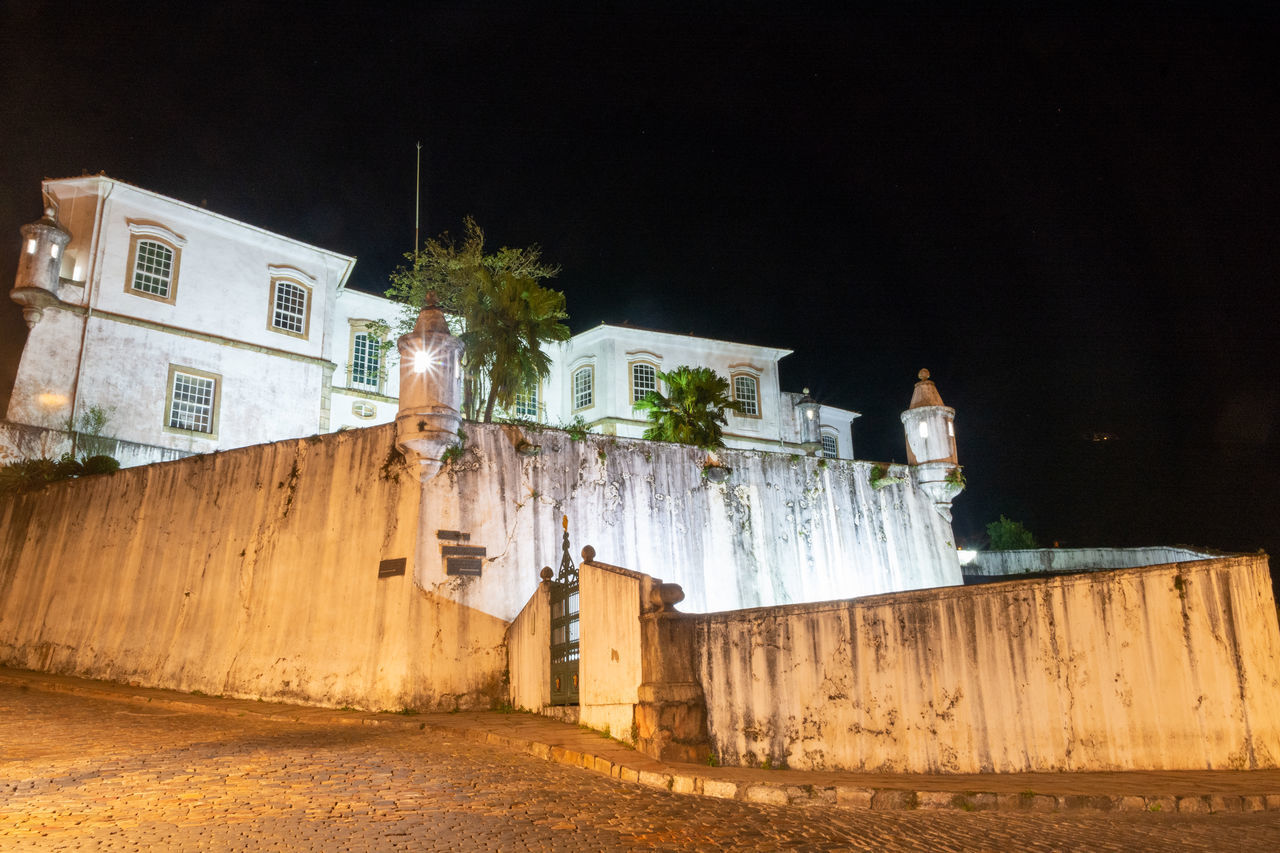 LOW ANGLE VIEW OF ILLUMINATED BUILDINGS AT NIGHT