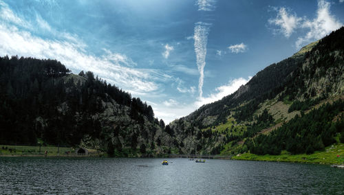 Scenic view of lake by trees against sky