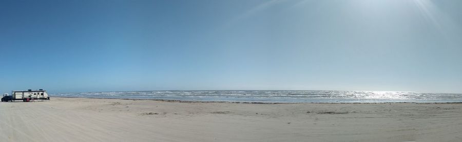 Scenic view of beach against clear blue sky