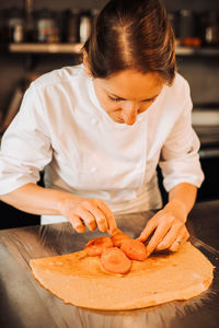 Female chef is making dessert with apricots and crepe