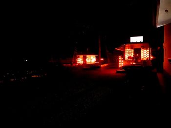 Illuminated street amidst buildings in city at night