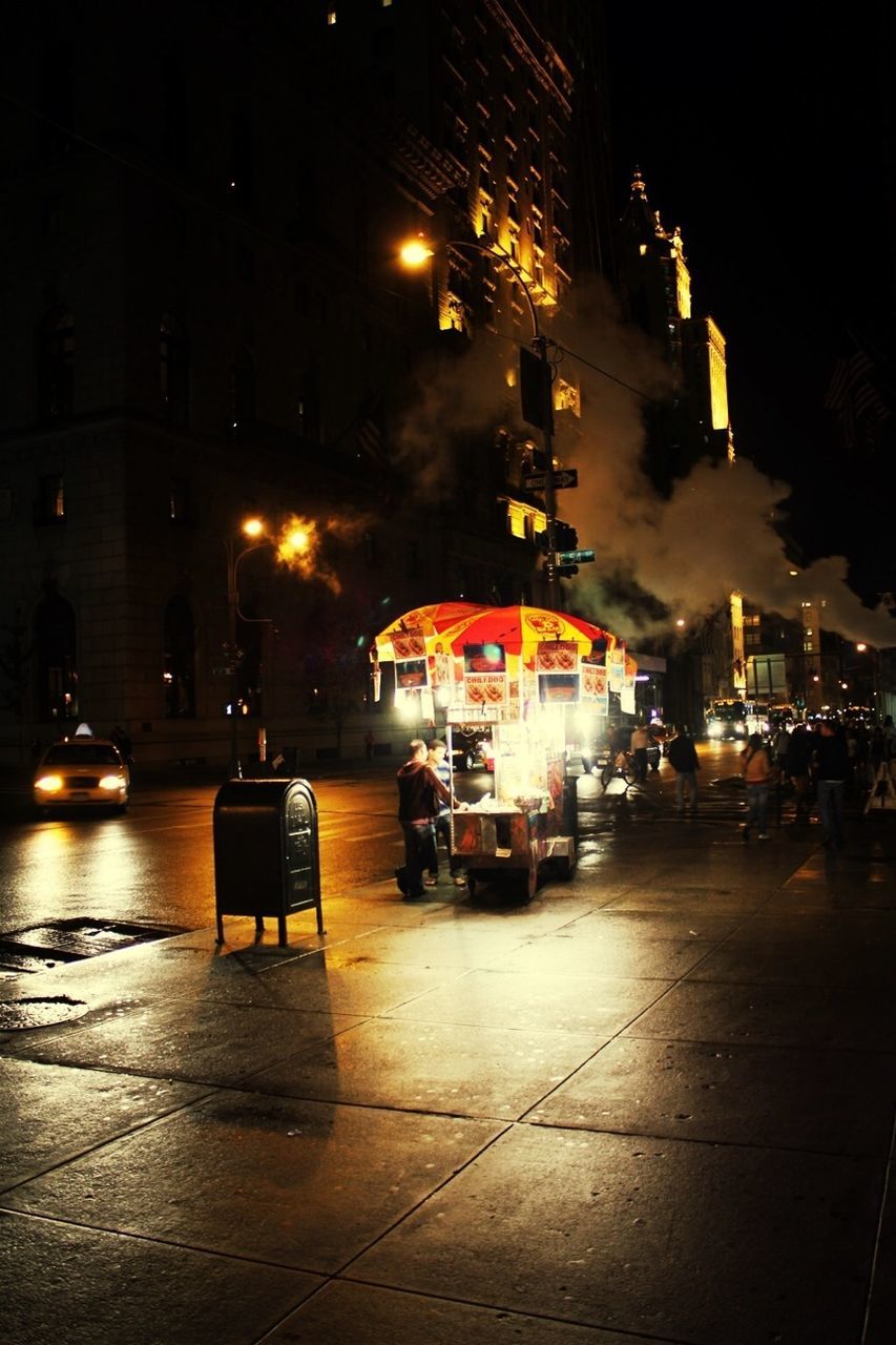 illuminated, night, building exterior, architecture, city, built structure, street, transportation, street light, car, mode of transport, lighting equipment, city street, land vehicle, city life, incidental people, road, building, outdoors, sky