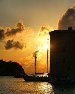 Silhouette of sailboats in sea during sunset