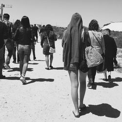 Rear view of people walking on beach