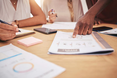 Midsection of business colleagues working on table