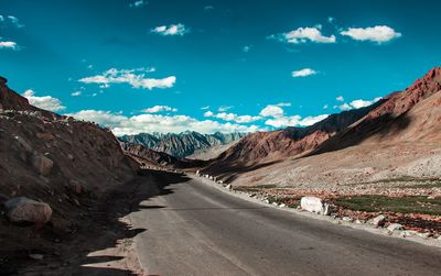 Road amidst mountains against sky