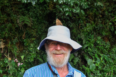 Portrait of man wearing hat against trees