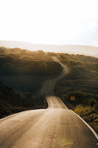 Road passing through landscape against sky