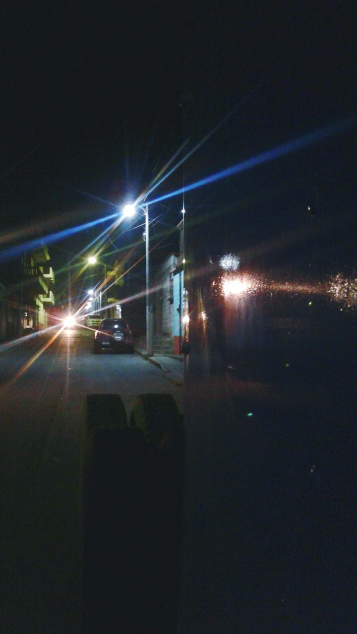 CARS ON ILLUMINATED ROAD AT NIGHT