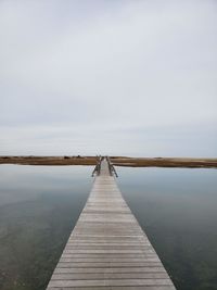 Pier over lake against sky