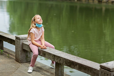 Portrait of smiling woman sitting on lake