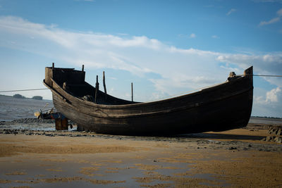 Fish boat on sea beach ,side view of a wooden fishing boat on tropical beach with white.