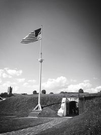 Flag on field against sky