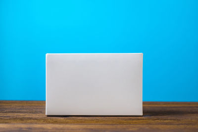 Close-up of white table against blue background