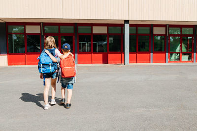 Back to school. brother and sister with backpacks on their backs go to school in an embrace. 