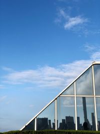 Low angle view of modern building against blue sky