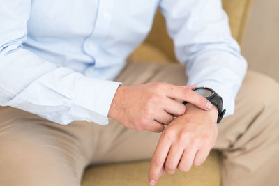 Midsection of man checking time in home