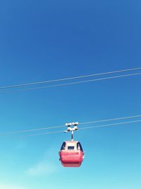 Low angle view of telephone pole against clear blue sky