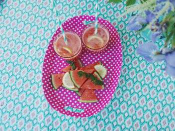 High angle view of watermelon slices with drink in plate on table