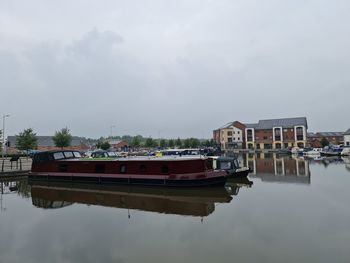 Boat moored on lake against sky