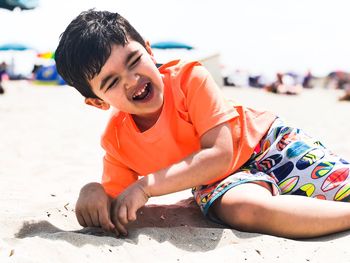 Boy wearing sunglasses on sand at beach