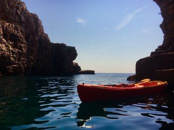 Kayak in sea against sky