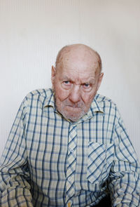 Senior man sitting against wall