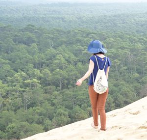 Rear view of young woman standing on mountain