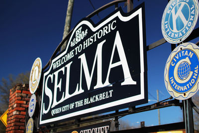 Low angle view of road sign against blue sky