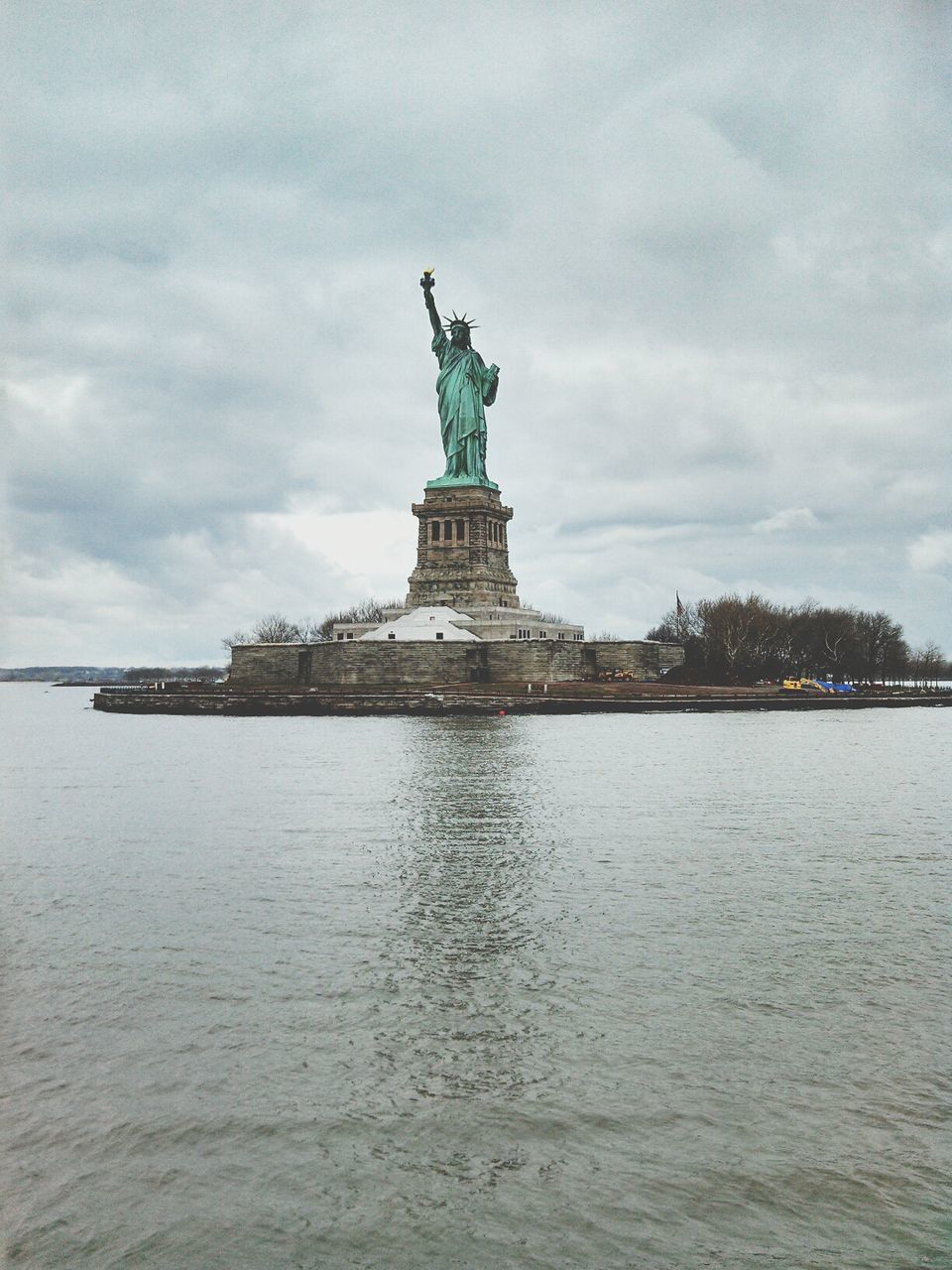 statue, human representation, sculpture, art and craft, art, sky, creativity, famous place, water, travel destinations, international landmark, waterfront, architecture, travel, built structure, statue of liberty, cloud - sky, building exterior