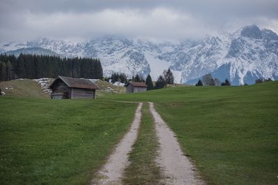 Houses on field by mountains against sky