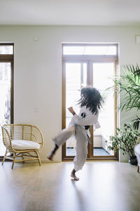 Active girl practicing karate in living room at home