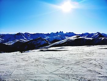 Scenic view of snowcapped mountains against blue sky